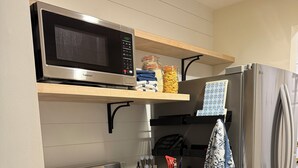 A compact kitchen with a stainless steel stove, microwave, and refrigerator. - Quiet Village Gem! Cozy retreat for two. (Stowe)