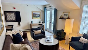 A cozy living room with a brown leather sofa, two armchairs, a coffee table, and a patterned rug. - Quiet Village Gem! Cozy retreat for two. (Stowe)