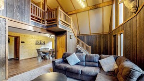 Ein gemütliches Interieur mit einer Holztreppe, einem Ledersofa und einem Essbereich.