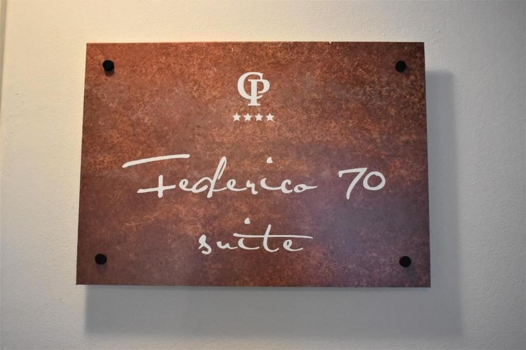 Un letrero con el texto 'Federico 70 suite' y un logotipo con tres estrellas.