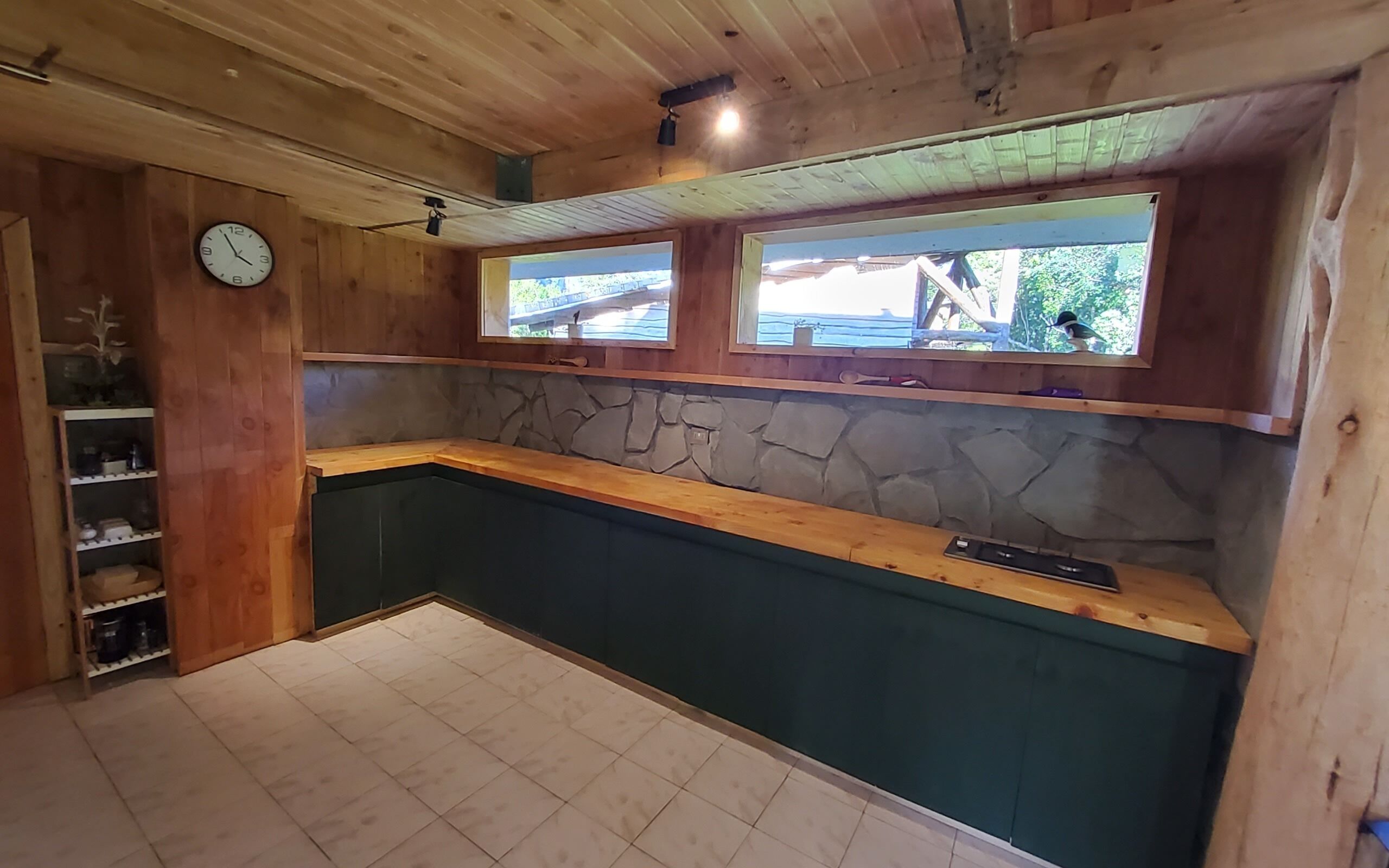 Una cocina con armarios de madera, salpicadero de piedra y ventana con vistas panorámicas.