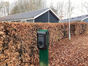 A green metal post with a black device labeled 'Clever' in front of a hedge. - 2 Person Holiday Home in Ansager (Ansager)