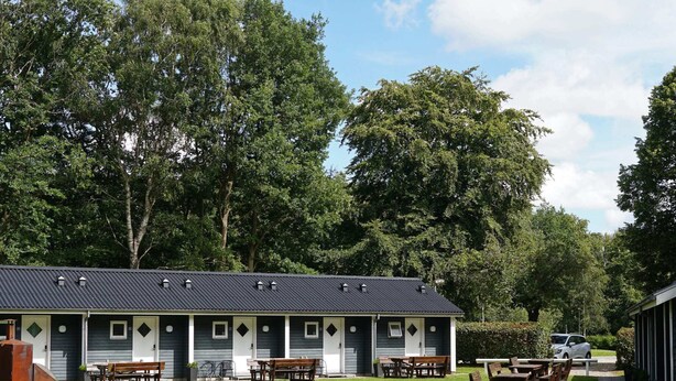 A motel with multiple rooms, outdoor seating, and a parking area. - 2 Person Holiday Home in Ansager (Ansager)