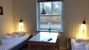 A room with a bed, a table, and a window with a view of trees. - 2 Person Holiday Home in Ansager (Ansager)