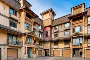 A multi-story building with a central courtyard, wooden balconies, and a sign indicating a restaurant. - Steamboat Slopeside Lodge (Steamboat Springs)