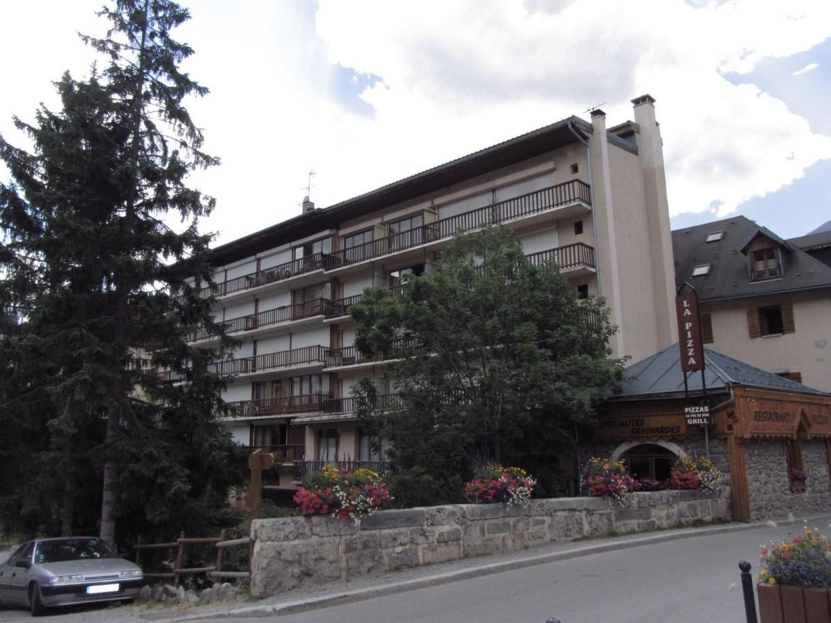 Un hôtel à plusieurs étages doté de balcons, d’un restaurant et d’un parking.