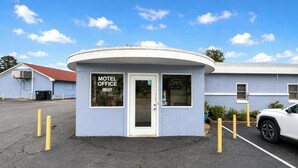 A small, single-story motel office with a white exterior and a red roof. - Imperial Motel Near Marion HWY 76 (Mullins)