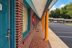 A hotel with a covered walkway, brick exterior, and a parking lot. - Imperial Motel Near Marion HWY 76 (Mullins)