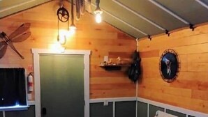 A cozy room with a bed, a small table, and a wall-mounted shelf.