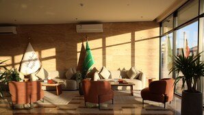 A modern lobby with a sofa, armchairs, a coffee table, and a flag.