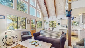 Un salon spacieux avec un haut plafond, de grandes fenêtres et un coin salon confortable.