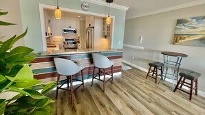 A modern kitchen with a central island, bar stools, and pendant lighting. - 🌴 Waterfront-Beach-Swimming-Fishing-Dock-Double sized private Balcony (Mary Esther)