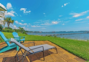 A patio with lounge chairs, a grassy area, and a view of the water. - Waterfront-Beach-Swimming-Fishing-Dock-Double sized private Balcony (Mary Esther)