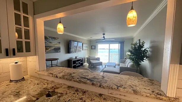 A kitchen with granite countertops, a built-in oven, and a large island. There is a dining area with a table and chairs visible through an open doorway. - 🌴 Waterfront-Beach-Swimming-Fishing-Dock-Double sized private Balcony (Mary Esther)