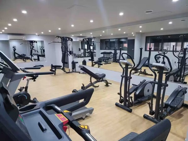 A gym with various exercise equipment, mirrors, and a wooden floor. - Free Indoor Parking in Old Montreal 4 (Montréal)