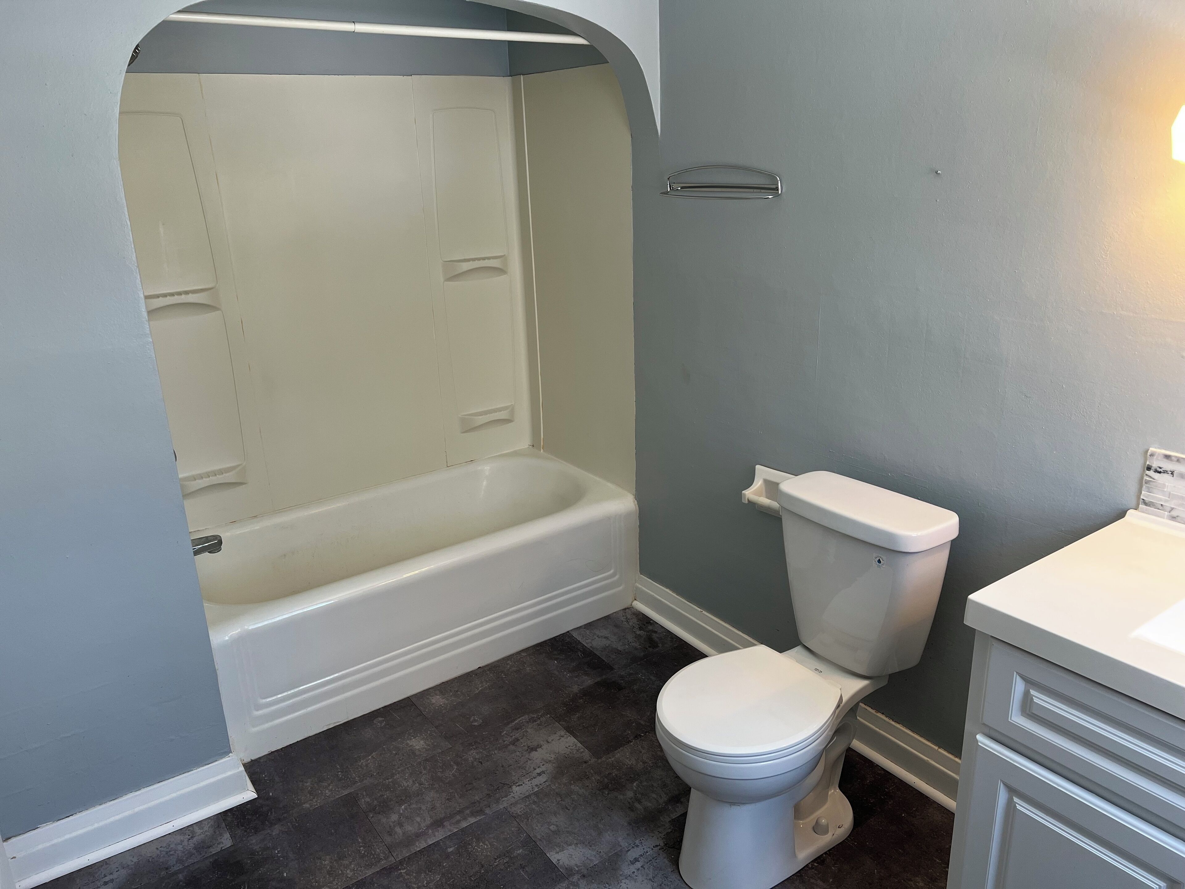A bathroom with a bathtub, toilet, and a sink.