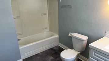 A bathroom with a bathtub, toilet, and a sink.