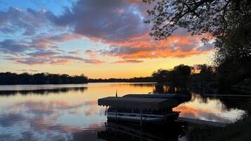 A calm lake at sunset with a docked boat.