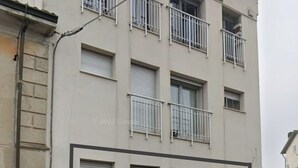 A multi-story building with balconies and a garage. - Holiday House iolo (Prato)