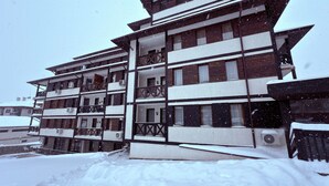 Ein mehrstöckiges Gebäude mit Balkonen, umgeben von Schnee.