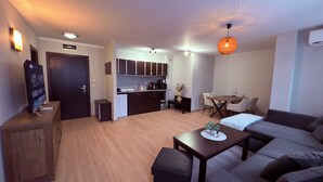 Ein kompakter Wohnbereich mit Küchenzeile, Essbereich und Sitzgelegenheit.