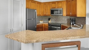 A kitchen with wooden cabinets, a stainless steel refrigerator, a microwave, and a stove. - JW Marriott's Desert Springs Villas I - Access to Marriott Spa, Sleeps 6-8 (Palm Desert)