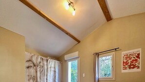 A bedroom with a bed, a nightstand, a window, a red chair, and a wall-mounted light fixture. - The birdies house (Trans-en-Provence)