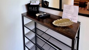 A hotel reception desk with a black metal frame, a welcome sign, a number sign, and a plant. - The birdies house (Trans-en-Provence)