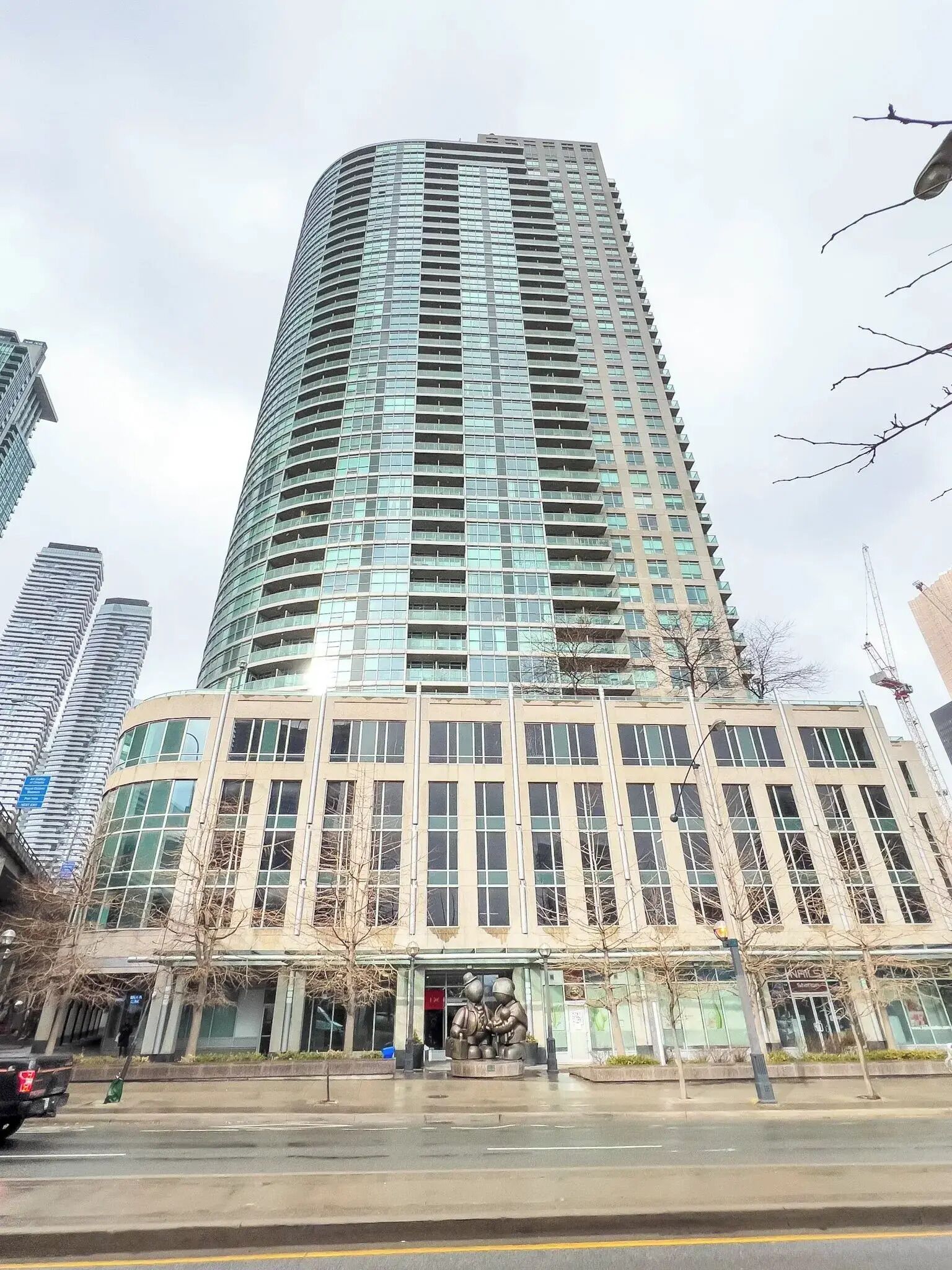 A tall, modern building with a curved facade and numerous windows.