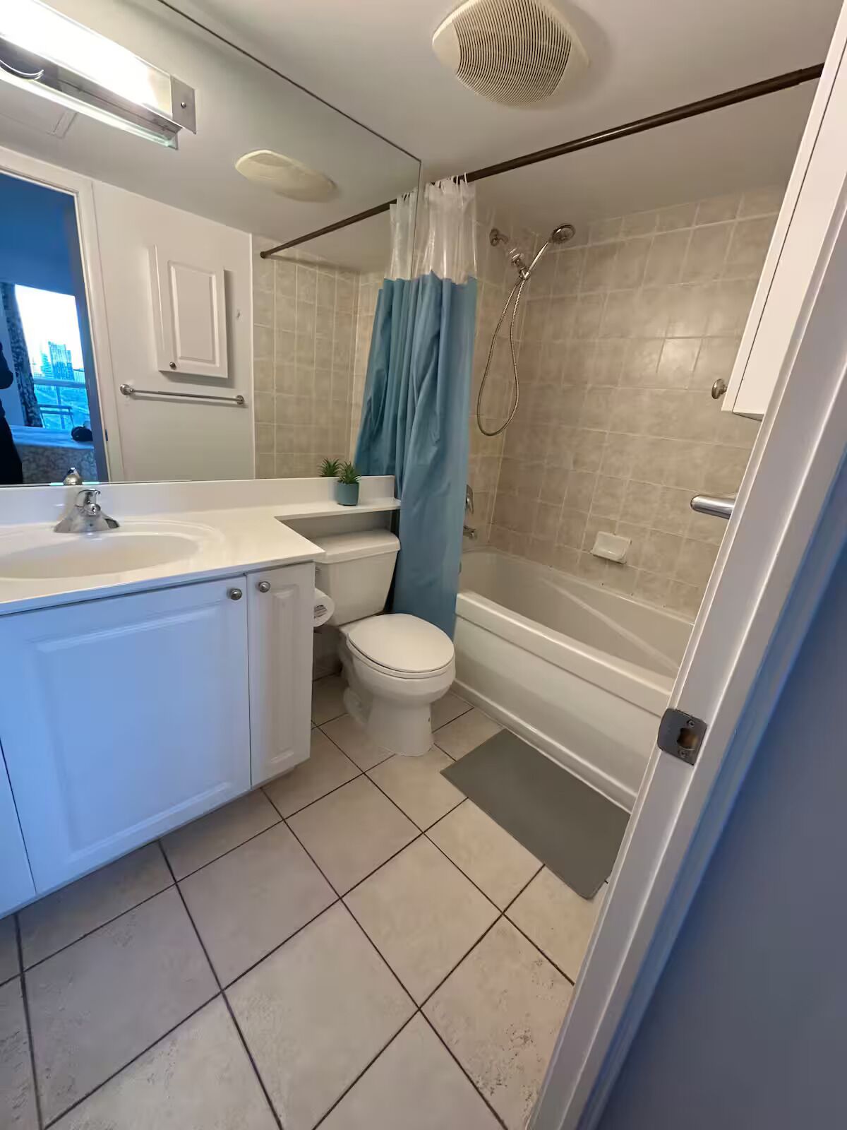 A bathroom with a white sink, toilet, and shower area.
