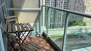 Ein Balkon mit Holzboden und einem Metalltisch.