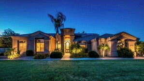 A modern house with a symmetrical facade, a central entrance with a covered porch, and well-maintained landscaping. - Saltwater Pool & Fire Pit: Luxe Queen Creek Oasis! (Queen Creek)