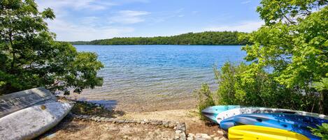 A lakeside view with kayaks and a wooden dock.
