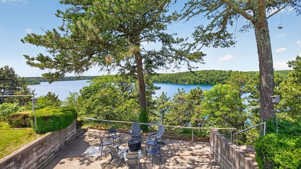 A patio with outdoor seating and a view of a lake. - 5 Bedrooms | Water Views | Private Pond Beach (Brewster)