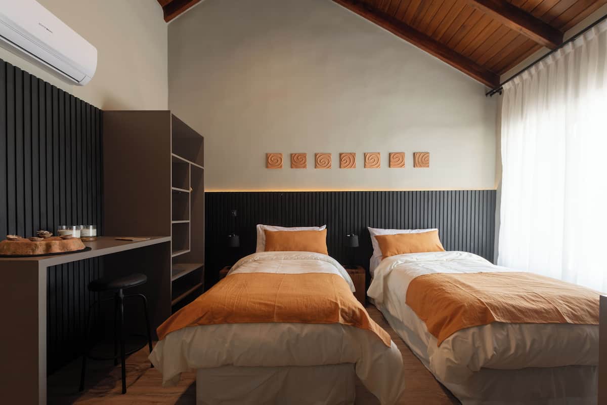Una habitación con dos camas, un escritorio y un armario.