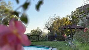 Une piscine dotée d’une terrasse en bois, entourée d’une pelouse et d’une clôture en bois.