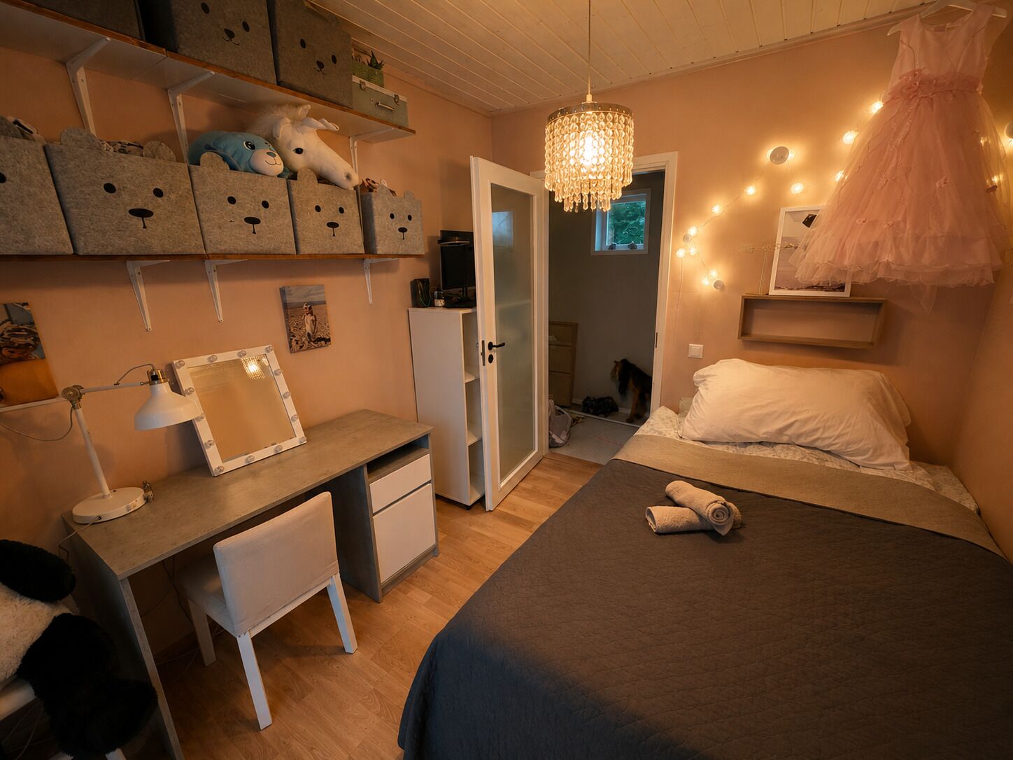 Une chambre avec un bureau, un lit à baldaquin, un miroir et des boîtes de rangement.