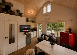 A modern kitchen with a flat-screen TV, a dining area with a table and chairs, a sofa, and a red refrigerator. - House Gotland at Tofta Strand - 3 bedrooms, fully equipped kitchen spacious veranda! (Tofta)