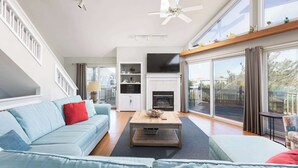A spacious living room with a large sofa, a coffee table, and a fireplace. - New Listing! Pool, Hot Tub & 2-Min Walk to Beach! (Corolla)