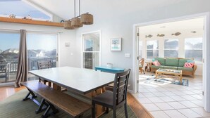 A spacious dining area with a large table, chairs, and a view through a glass door. - New Listing! Pool, Hot Tub & 2-Min Walk to Beach! (Corolla)