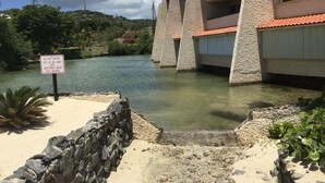 Um edifício com fachada de pedra e telhado de telhas vermelhas, com vista para um corpo de água.