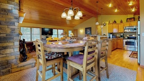 A cozy kitchen with wooden cabinets, a dining table with chairs, and a stone fireplace. - Pool & Beach Access! 'Lake Arrowhead Hideaway' (Nekoosa)