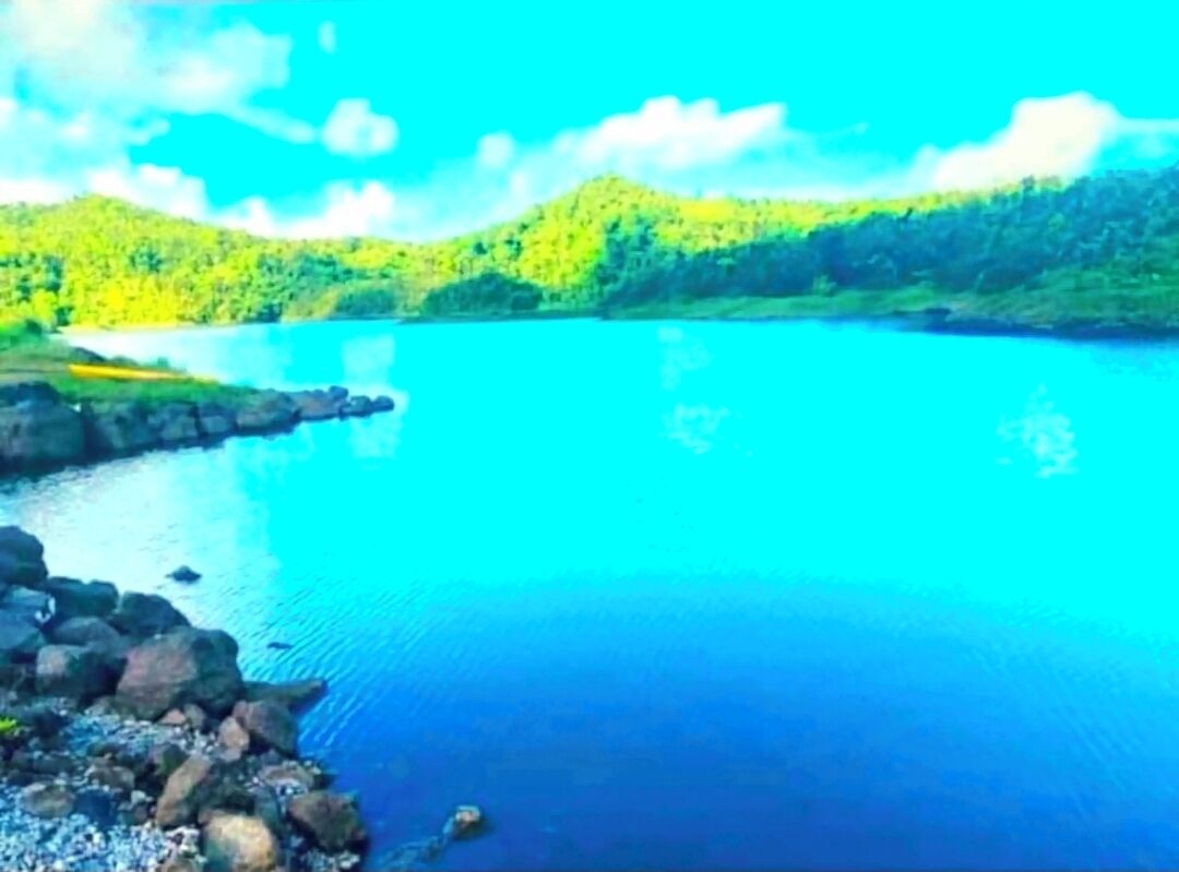 Un lago tranquilo rodeado de colinas verdes.
