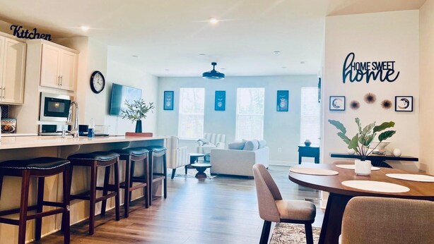 A modern kitchen with a dining area, a living room, and a kitchen island.