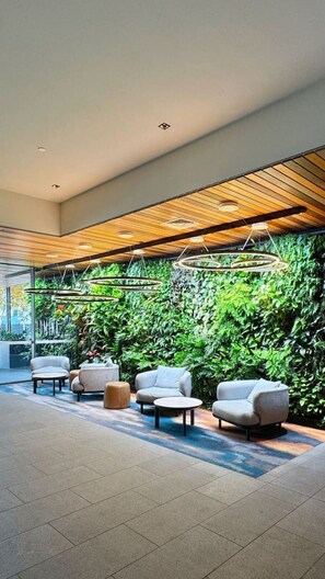 A modern lobby with a green wall, seating area, and wooden ceiling. - Amazing Views - 2BD 2BA Homey Toowong Abode + Pool (Toowong)