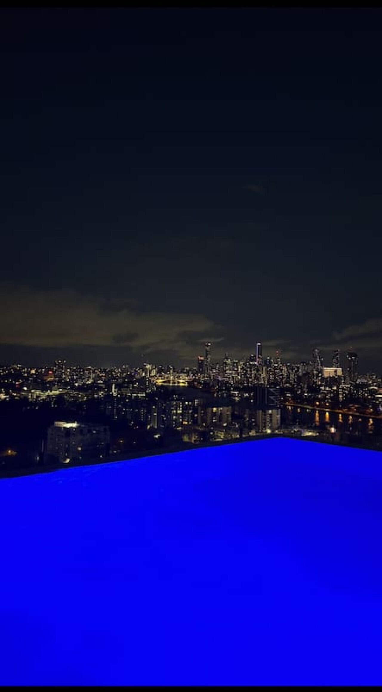 A nighttime cityscape with illuminated buildings.
