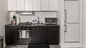 Una cocina compacta equipada con estufa a gas, microondas, horno y refrigerador.