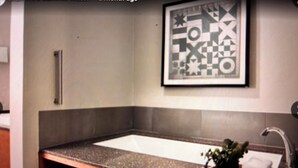 A bathroom with a wooden vanity, a sink, and a framed abstract artwork on the wall. - Special Discount: Stay on Main Street for New Year's in 2 Bedroom Villa (Park City)