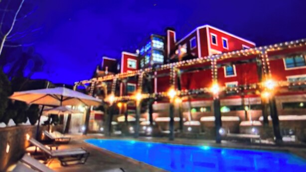 A hotel with a swimming pool, lounge chairs, and umbrellas. - Special Discount: Stay on Main Street for New Year's in 2 Bedroom Villa (Park City)