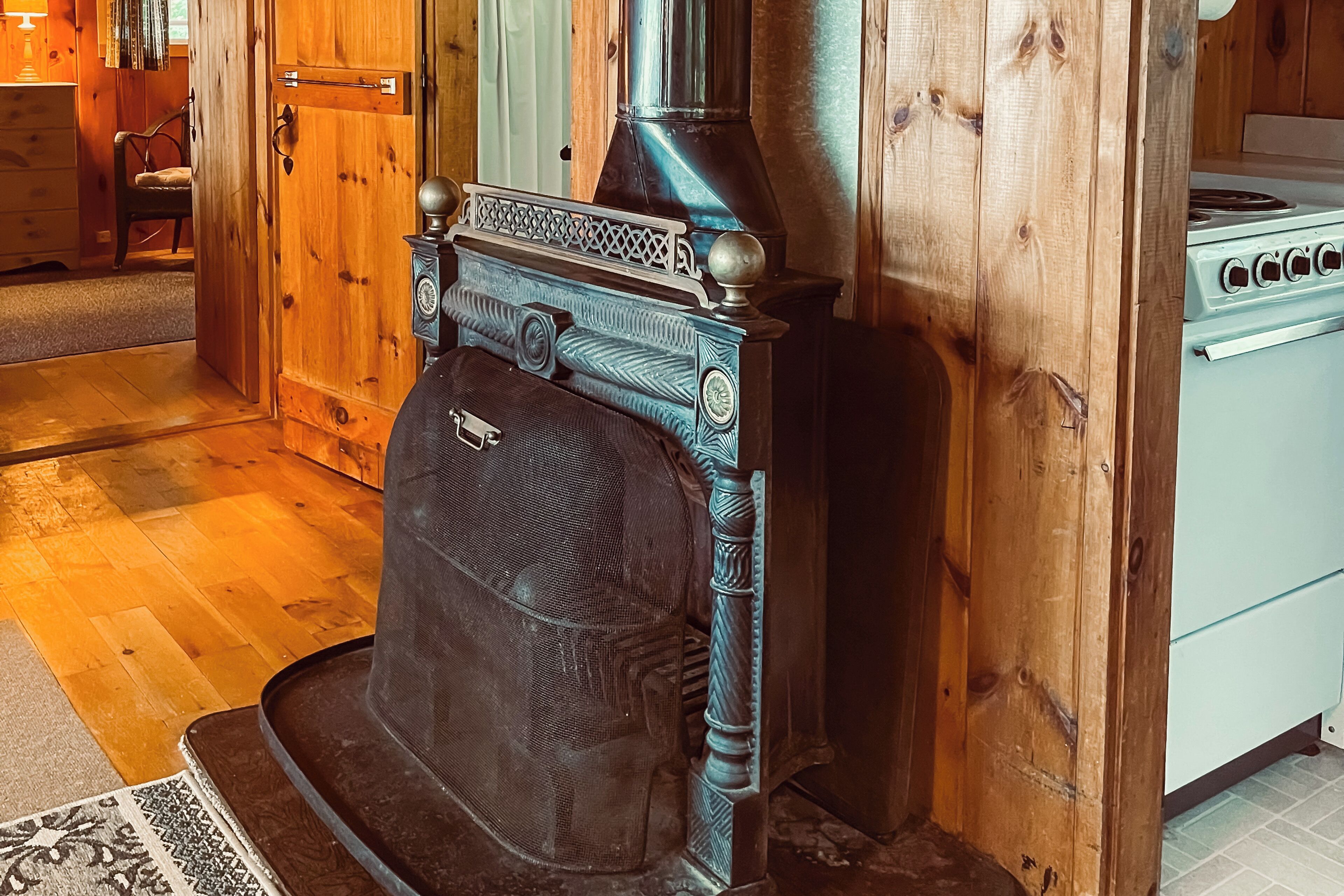 Un poêle à bois traditionnel agrémenté d’une cheminée décorative, un four de style ancien et un intérieur en bois.
